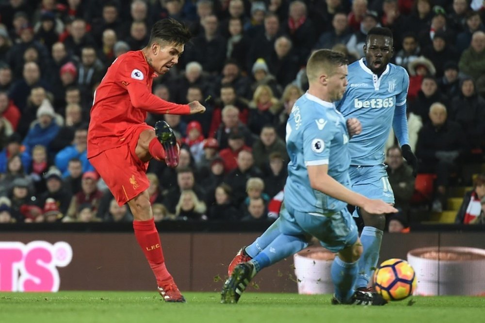 Liverpools midfielder Roberto Firmino (L) scores Liverpools second goal during the English Premier League football match between Liverpool and Stoke City at Anfield in Liverpool, north west England on December 27, 2016
