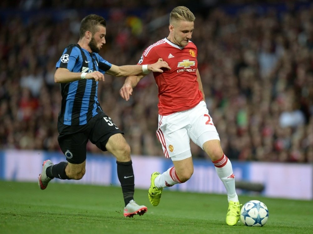 Club Brugges Tuur Dierckx (L) challenges Manchester Uniteds Luke Shaw during their UEFA Champions League play-off first leg match, at Old Trafford in Manchester, on August 18, 2015