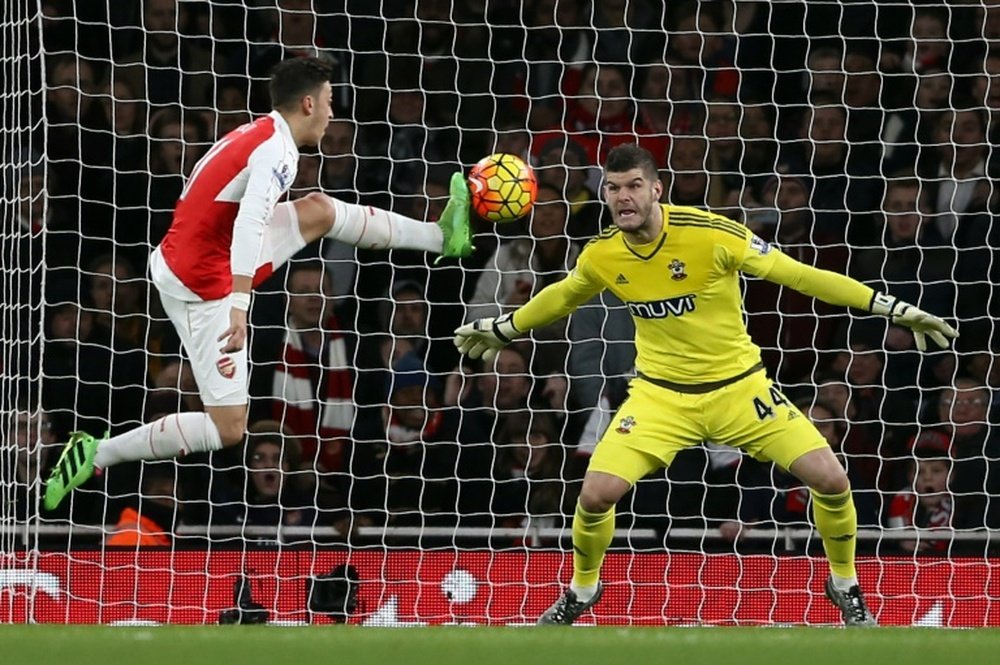 Arsenals Mesut Ozil (L) fails to score past Southampton keeper Fraser Forster during their English Premier League match at the Emirates Stadium