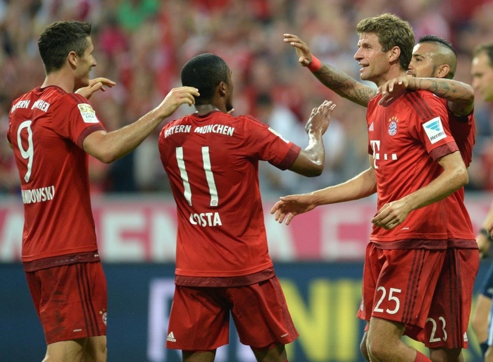 Bayern Munichs players celebrate after the fourth goal for Munich during their German first division Bundesliga match against Hamburg, at the Allianz Arena in Munich, southern Germany, on August 14, 2015