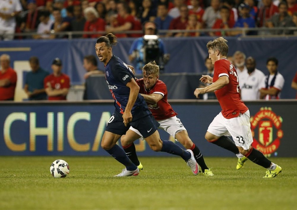 Paris Saint-Germains Zlatan Ibrahimovic makes a break past Manchester Uniteds Luke Shaw (C) and Bastian Schweinsteiger during their International Champions Cup match in Chicago, Illinois on July 29, 2015