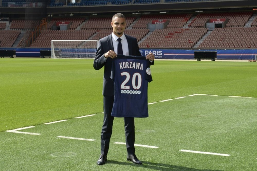 Paris Saint-Germain newly recruited defender Layvin Kurzawa poses with his new jersey during his official presentation on August 28, 2015 at the Parc des Princes in Paris