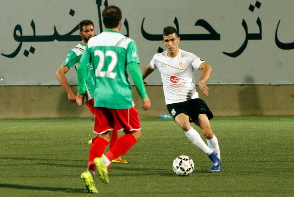 Shebab Hebrons Israeli Arab player Abu Obeideh Rabie (R) dribbles the ball during a football match against the Ammari Youth Club, at the Hebron Youth Club on April 7, 2016
