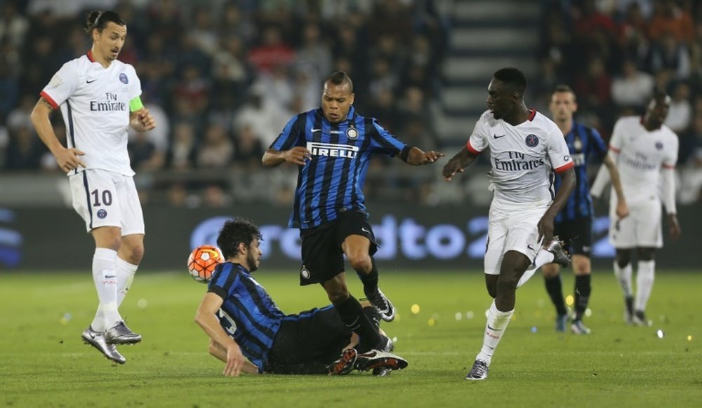 Paris Saint-Germain forward Jean-Kevin Augustin (R) fights for the ball with Inter Milans Jonathan Biabiany (C) during the friendly football match in Doha, on December 30, 2015