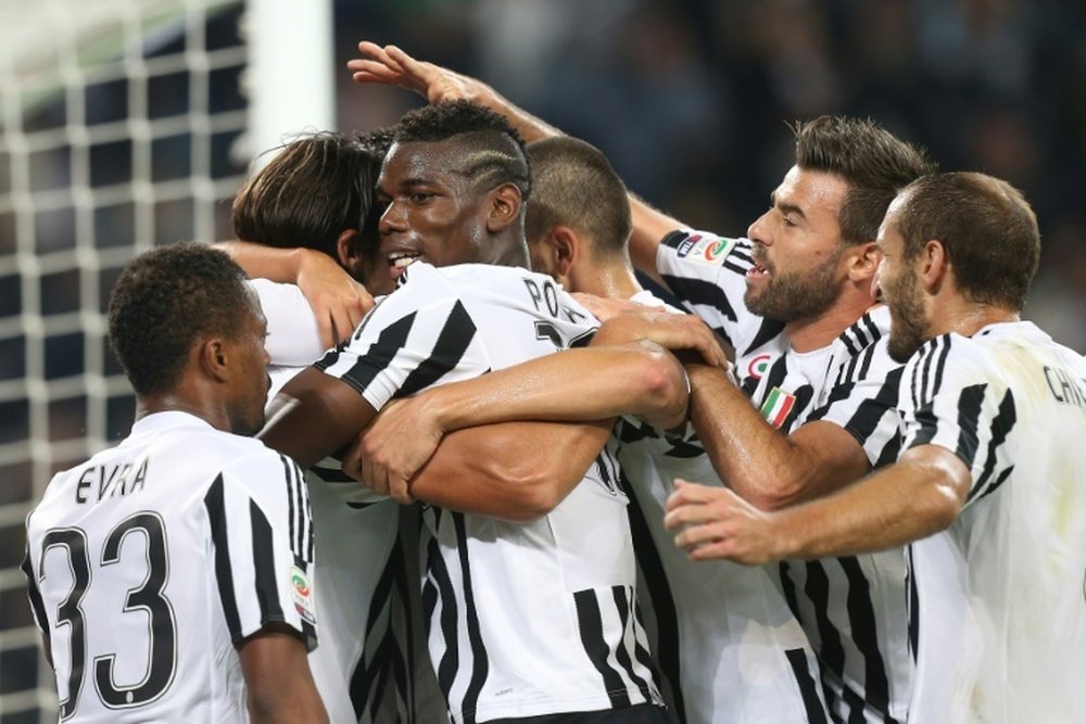 Juventus' players celebrate scoring a goal during their Italian Serie A match against Bologna, at the Juventus Stadium in Turin, on October 4, 2015