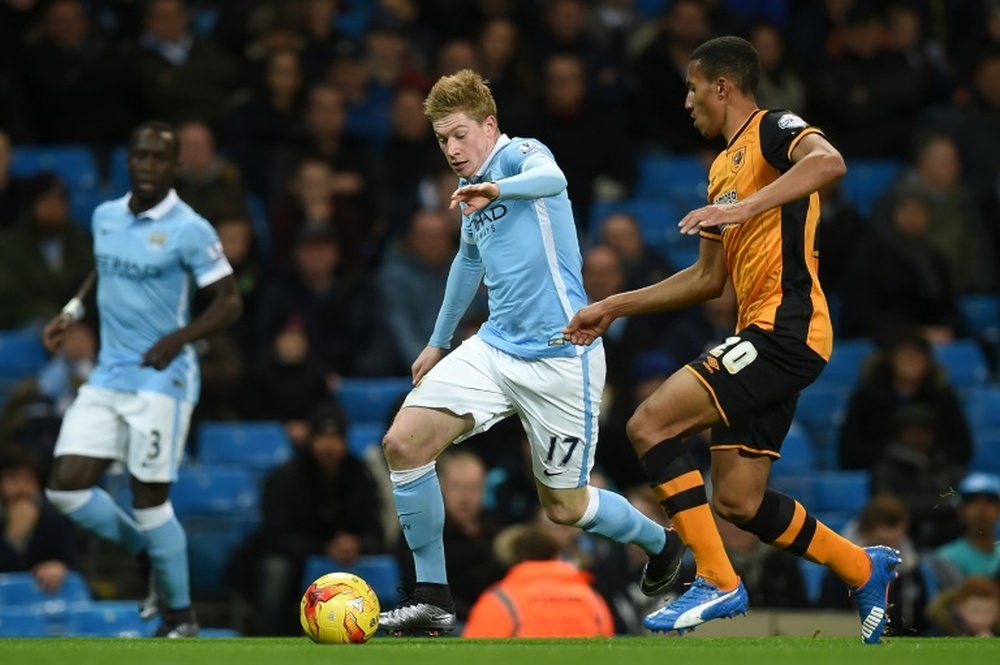Manchester Citys midfielder Kevin De Bruyne (C) is tracked by Hull Citys defender Isaac Hayden during an English League Cup quarter-final football match at the Etihad Stadium on December 1, 2015