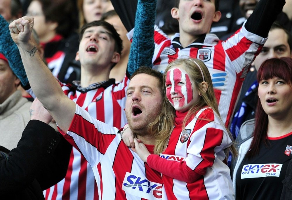 Brentford supporters cheer for their team during the fourth round replay English FA Cup football match between Chelsea and Brentford at Stamford Bridge in London on February 17, 2013