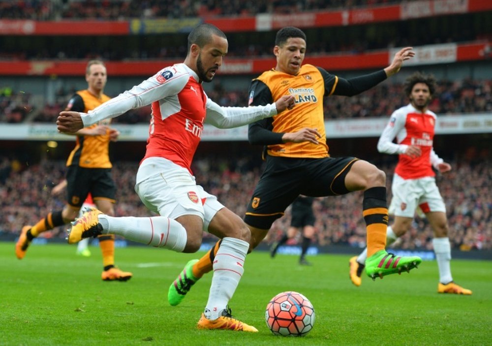 Arsenals midfielder Theo Walcott (L) crosses the ball by Hull Citys defender Curtis Davies during the FA cup fifth round football match in London on February 20, 2016