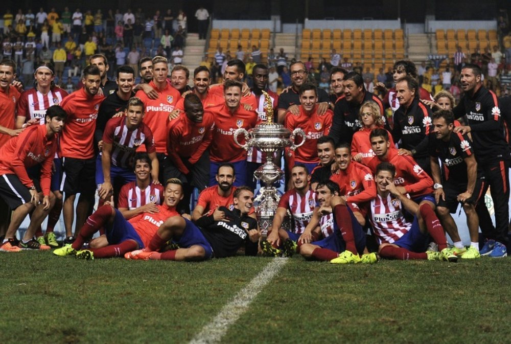 Atletico Madrids players pose with the trophy after winning the Trofeo Carranza in Cadiz on August 15, 2015