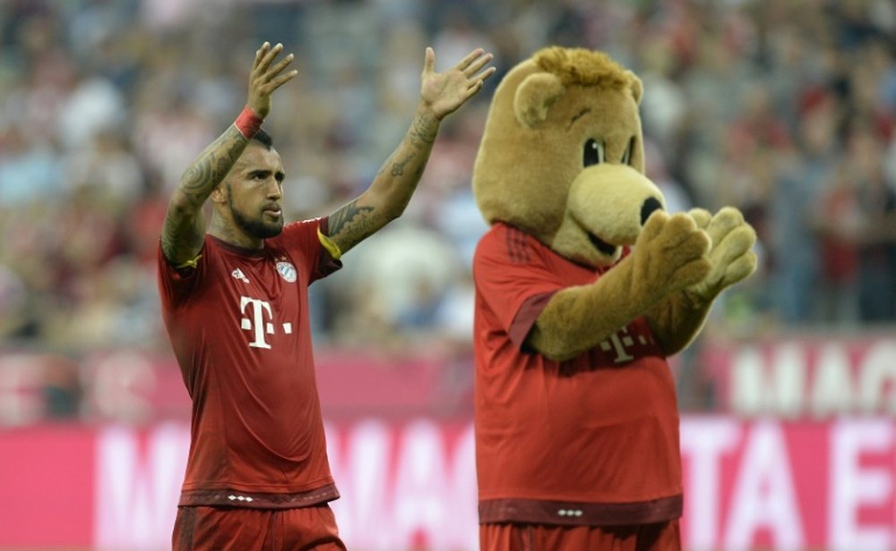 Arturo Vidal with the Bayern Munich mascot after the match against Bayer Leverkusen in Munich on August 29, 2015