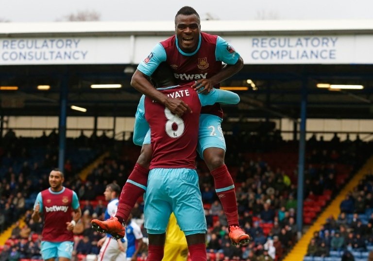 West Hams Nigerian striker Emmanuel Emenike (top) celebrates with teammate Cheikhou Kouyate after scoring their third goal during the FA Cup fifth round against Blackburn at Ewood Park in Blackburn, north-west England on February 21, 2016