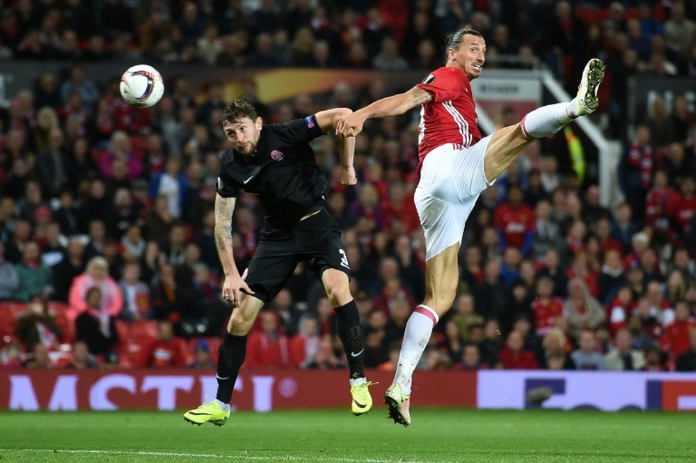 Manchester Uniteds striker Zlatan Ibrahimovic (R) vies in the air with Zoryas Belarusian defender Mikhail Sivakov as he heads the ball towards goal during the UEFA Europa League group A football match between Manchester United and Zorya Luhansk
