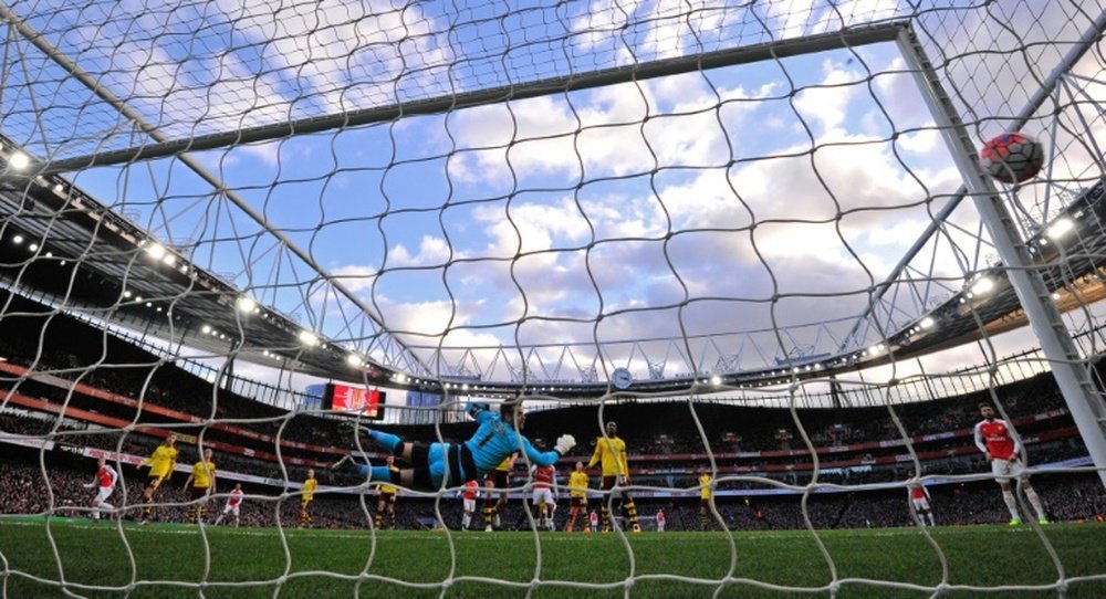 Arsenals Calum Chambers (L) watches his shot as he scores his teams second goal during the English FA Cup fourth round match against Burnley at the Emirates stadium in London, on January 30, 2016