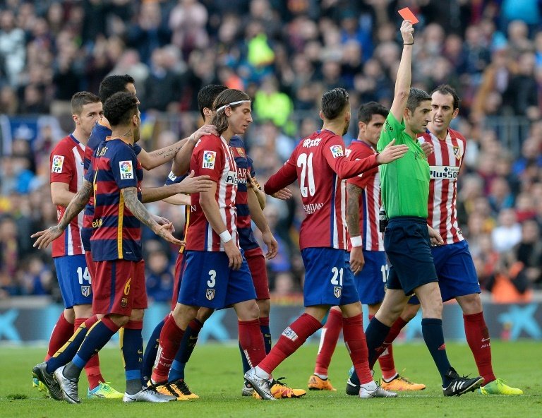 Atletico Madrids defender Filipe Luis (2ndL) looks dejected after he was shown a red card during the Spanish league football match FC Barcelona vs Club Atletico de Madrid at the Camp Nou stadium in Barcelona on January 30, 2016