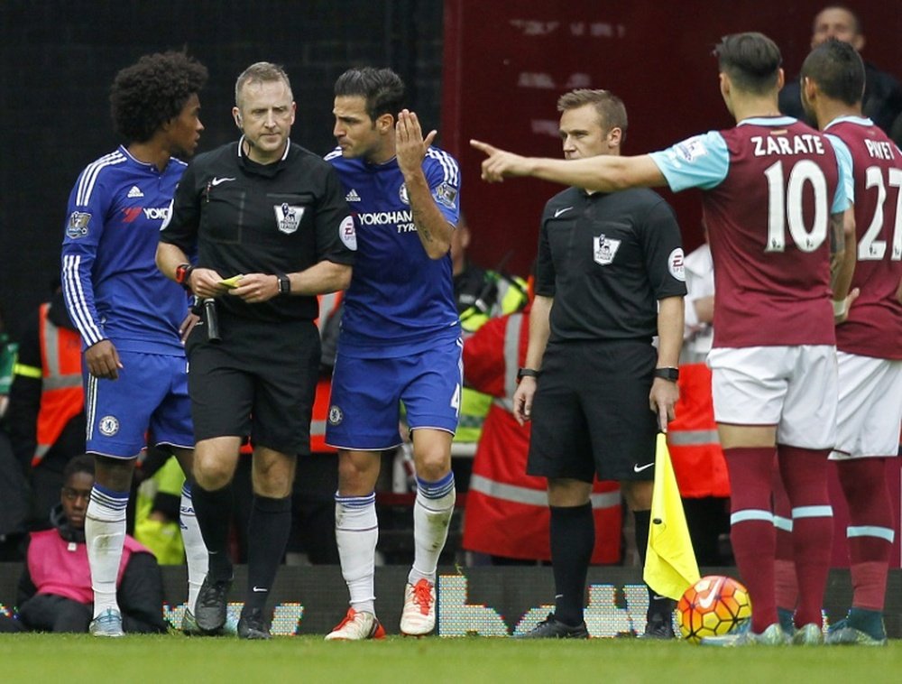 Chelsea midfielder Cesc Fabregas (3L) speaks with the referee following a challenge by midfielder Nemanja Matic on West Ham United striker Diafra Sakho during the match on October 24, 2015