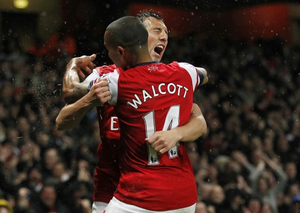 Arsenals Theo Walcott (front) celebrates scoring a goal with Spanish midfielder Santi Cazorla during the English Premier League match against Wigan Athletic at The Emirates Stadium in London on May 14, 2013RESTRICTED TO EDITORIAL USE. No use with unauthorised audio, video, data, fixture lists, club/league logos or Ã¢ÂÂliveÃ¢ÂÂ services. Online in-match use limited to 45 images, no video emulation. No use in betting, games or single club/league/player publications.