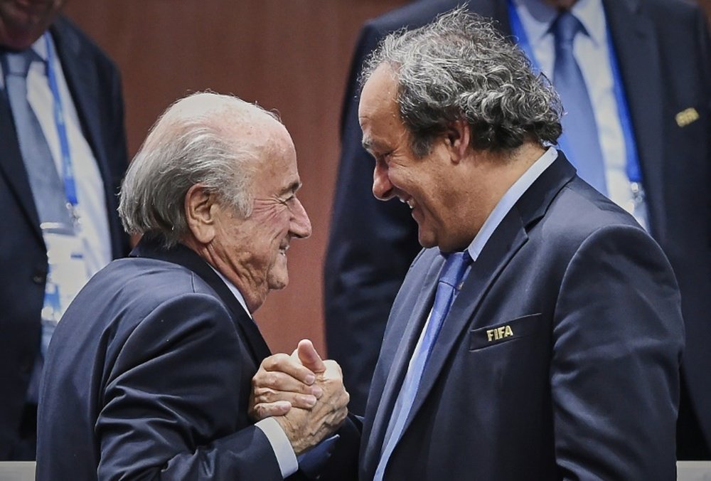 FIFA president Sepp Blatter (L) shakes hands with UEFA president Michel Platini after being re-elected following a vote to decide on the FIFA presidency in Zurich, on May 29, 2015