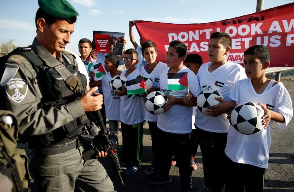 Palestinian youths are blocked by Israeli security forces in the West Bank as they protest ahead of a key FIFA meeting to discuss teams from Israeli settlements, on October 11, 2016