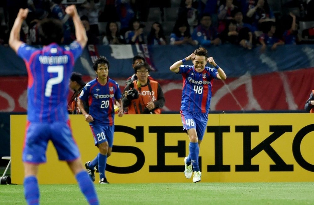 FC Tokyos Kota Mizunuma (right) celebrates after scoring against Shanghai SIPG in the AFC Champions League on May 17, 2016
