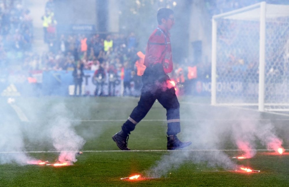 A fire fighter extinguish flares lobed onto the pitch during the Euro 2016 group D football match between Czech Republic and Croatia at the Geoffroy-Guichard stadium in Saint-Etienne on June 17, 2016