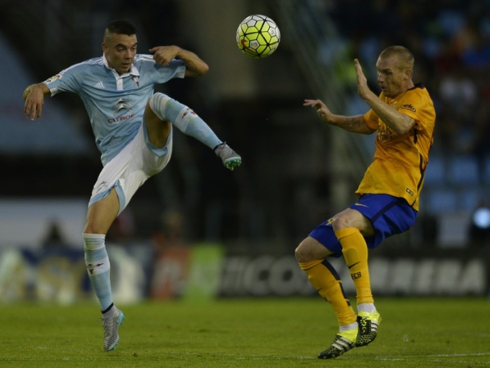 Celta Vigos Iago Aspas (L) fights for the ball with Barcelonas Jeremy Mathieu during their Spanish La Liga match, at the Balaidos stadium in Vigo, on September 23, 2015