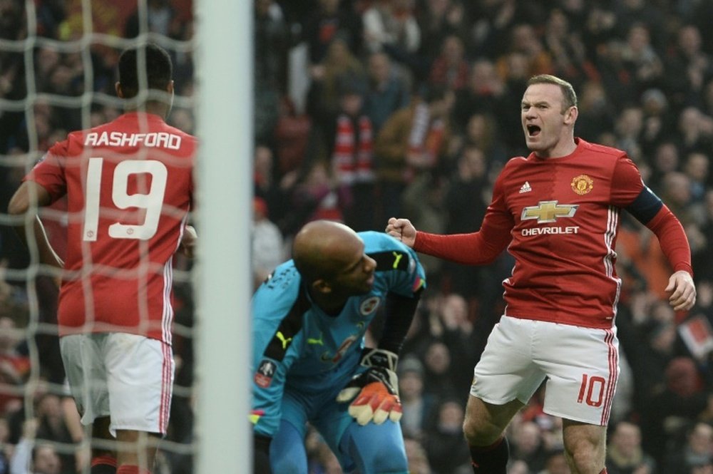 Manchester Uniteds Wayne Rooney (R) celebrates scoring the opening goal and equalling Bobby Charltons Manchester United all-time scoring record during the English FA Cup third round football match between Manchester United and Reading
