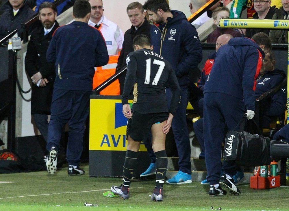 Arsenals Chilean striker Alexis Sanchez limps off the pitch holding his leg during the English Premier League football match between Norwich City and Arsenal at Carrow Road in Norwich, eastern England on November 29, 2015