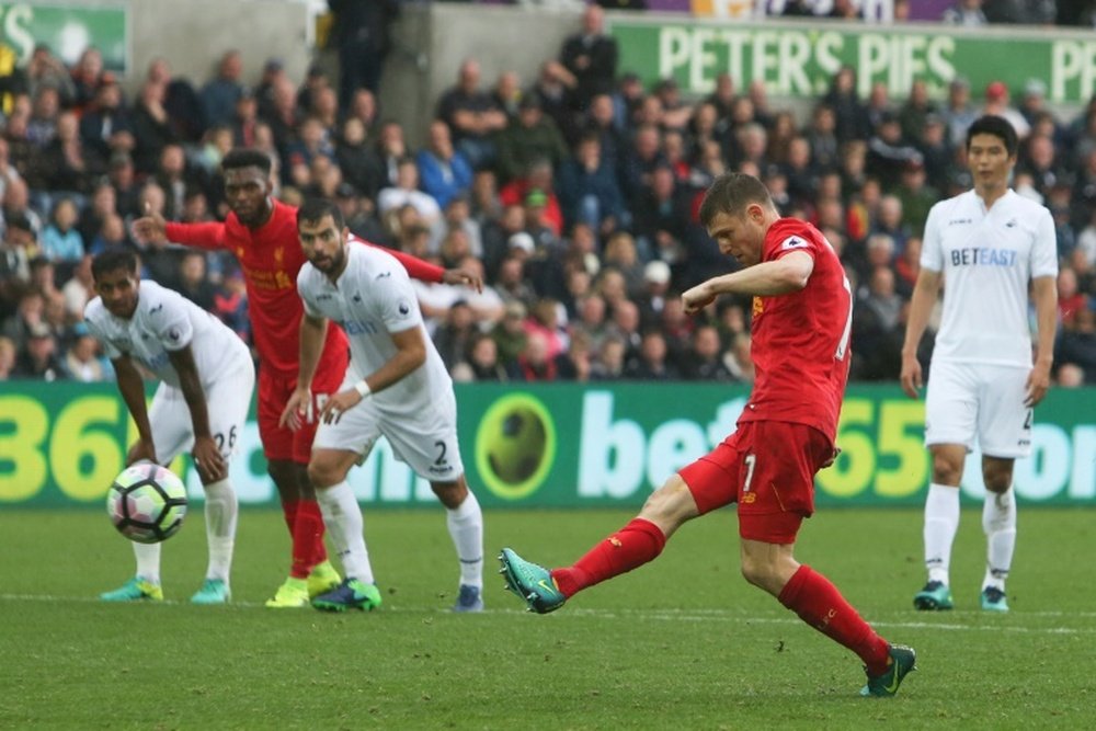 Liverpools English midfielder James Milner (2R) scores their second goal against Swansea City from the penalty spot to take the lead 1-2 during an English Premier League football match in Swansea, south Wales on October 1, 2016