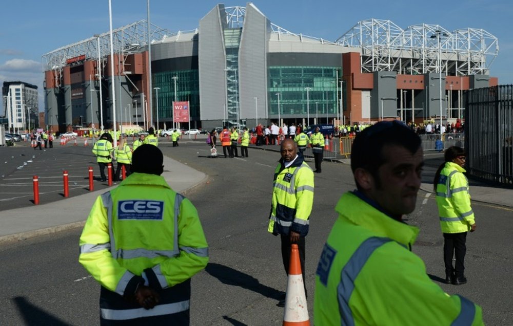 Event staff stand outside the evacuated Old Trafford stadium in Manchester on May 15, 2016 following a bomb scare