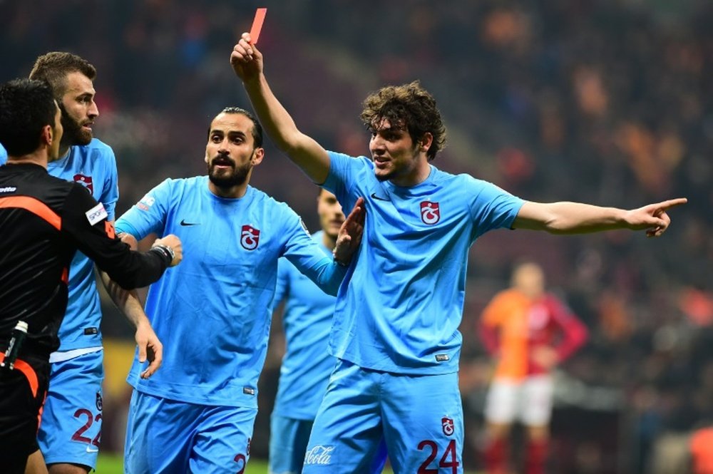 Trabzonspors player Salih Dursun (R) shows a red card to referee Deniz Ates Bitnel (L) during a Turkish Super Lig football match against Galatasaray on Feburary 21, 2016 at the TT Arena Stadium in Istanbul