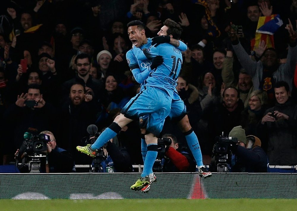 Barcelonas forward Neymar (L) congratulates Lionel Messi after Messi scored the teams second goal from the penalty spot during the UEFA Champions League match against Arsenal at the Emirates Stadium in London on February 23, 2016