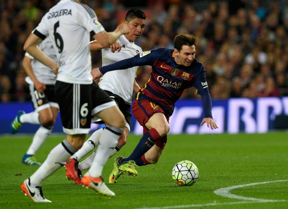 Barcelonas forward Lionel Messi (R) fights for the ball with Valencias midfielder Enzo Perez on April 17, 2016