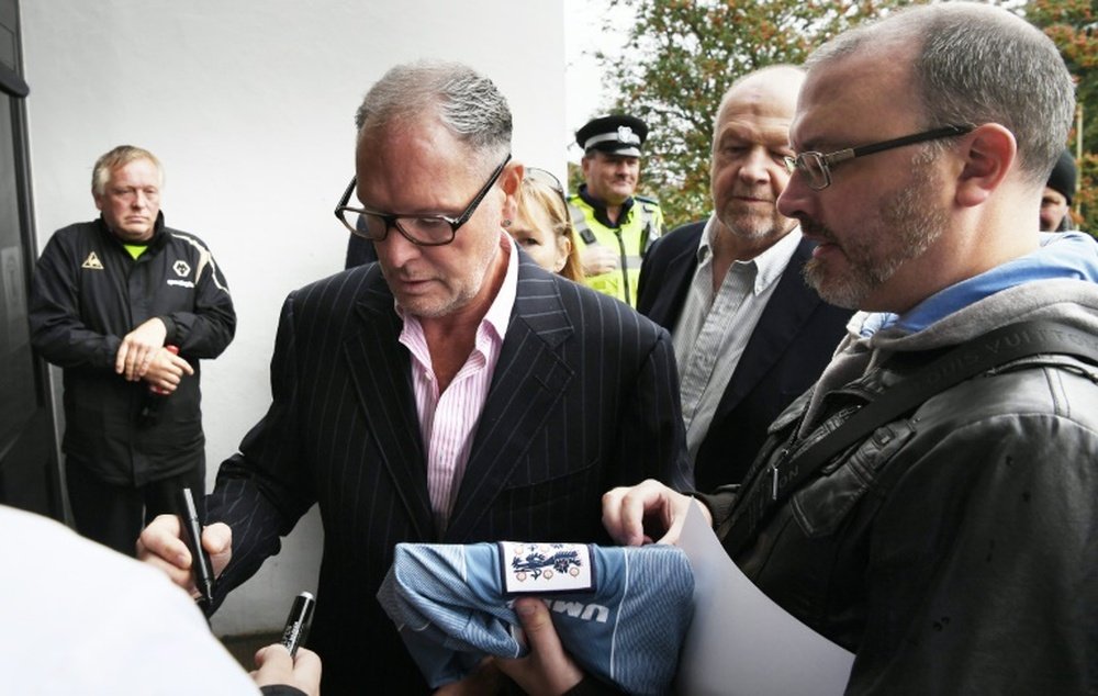 Paul Gascoigne (2L) signs autographs as he arrives at Dudley Magistrates Court. AFP