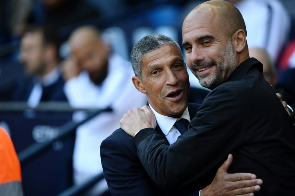 Hughton pictured with Pep Guardiola. AFP