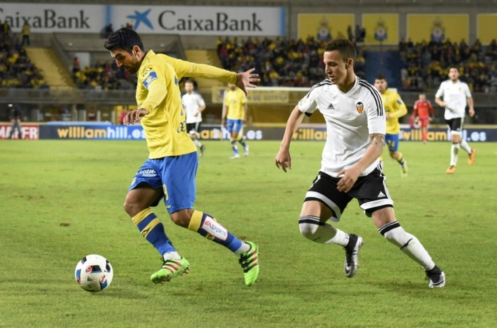 Valencias forward Rodrigo (L) runs from Las Palmas midfielder Emmanuel Culio during the Spanish Copa del Rey football match at the Estadio de Gran Canaria in Las Palmas de Gran Canaria on January 28, 2016