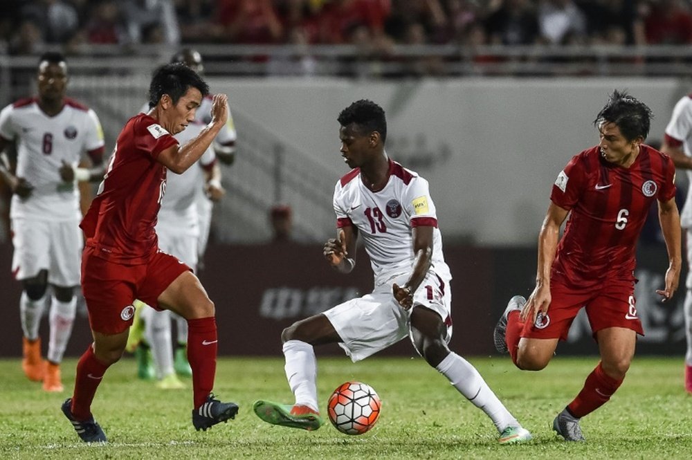 Qatars Mohammed Muntari (C) dribbles the ball past Hong Kongs Huang Yang (R) during their 2018 World Cup football qualifying match in Hong Kong on September 8, 2015