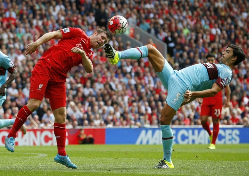 West Ham Uniteds English defender James Tomkins (R) challenges Liverpools English midfielder James Milner during the English Premier League football match at the Anfield stadium in Liverpool, north-west England on August 29, 2015
