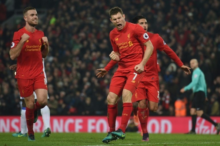 Liverpools midfielder James Milner (C) celebrates after scoring their second goal from the penalty spot with midfielder Jordan Henderson (L) and midfielder Emre Can (R) during the Premier League football match against Sunderland November 26, 2016