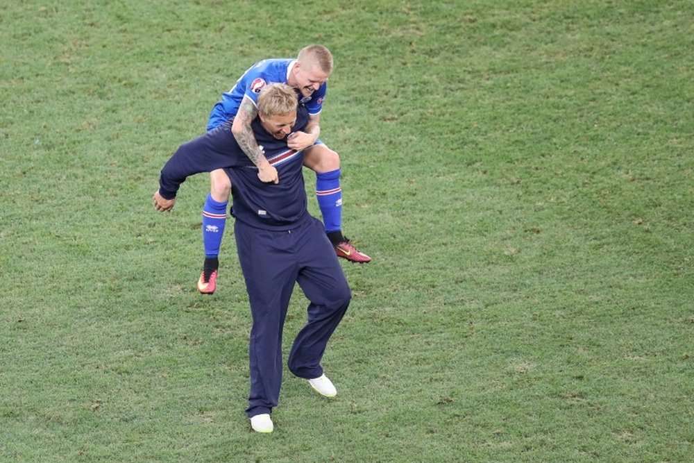 Icelands coach Heimir Hallgrimsson (bottom) celebrates his teams win with Icelands defender Ari Skulason after the Euro 2016 round of 16 football match between England and Iceland at the Allianz Riviera stadium in Nice on June 27, 2016