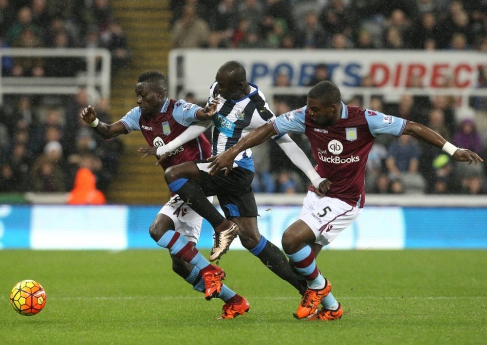 Aston Villas defender Jores Okore (R) and midfielder Idrissa Gueye (L) challenge Newcastle Uniteds striker Papiss Cisse during the English Premier League football match in Newcastle-upon-Tyne, north east England on December 19, 2015