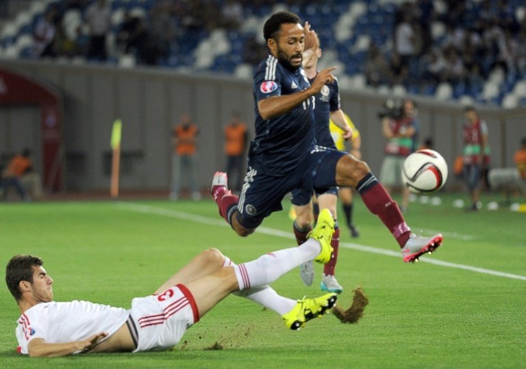 Ikechi Anya (R) of Scotland leaps clear of a tackle from Solomon Kverkvelia of Georgia during their Euro 2016 qualifying match in Tbilisi on September 4, 2015