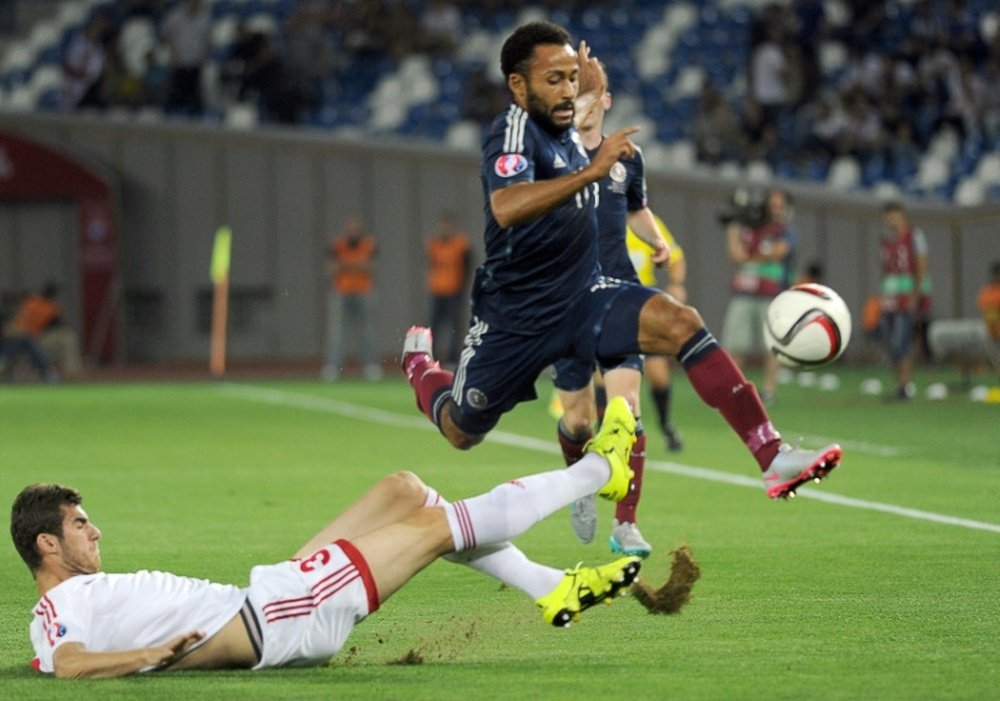 Ikechi Anya (R) of Scotland leaps clear of a tackle from Solomon Kverkvelia of Georgia during their Euro 2016 qualifying match in Tbilisi on September 4, 2015