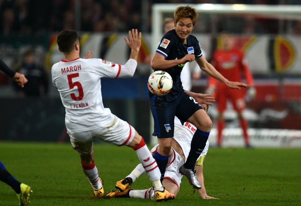 Herthas midfielder Genki Haraguchi and Colognes defender Dominic Maroh vie for the ball during the German first division Bundesliga football match in Cologne, Germany, on February 26, 2016