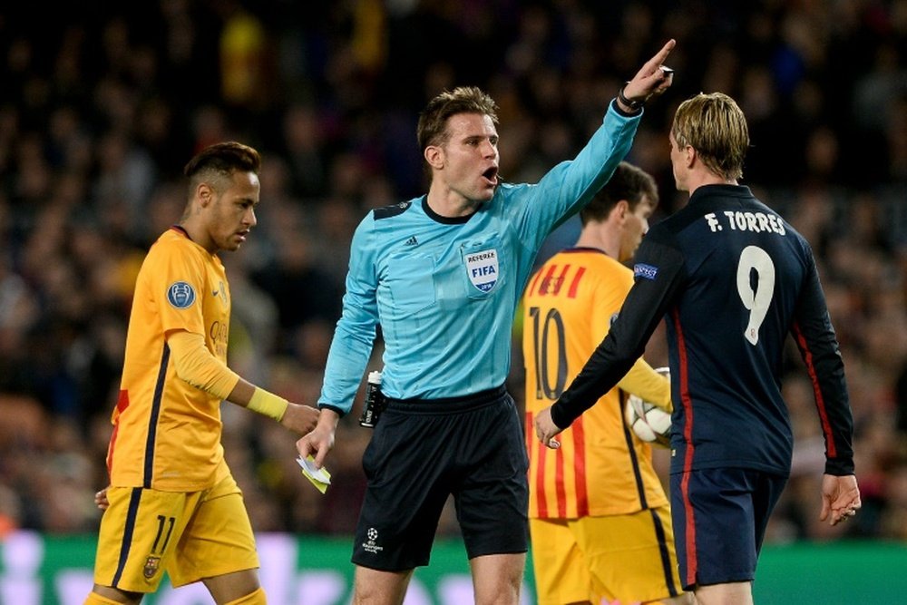 German referee Felix Brych (C) yells at Atletico Madrids forward Fernando Torres (R) on April 5, 2016