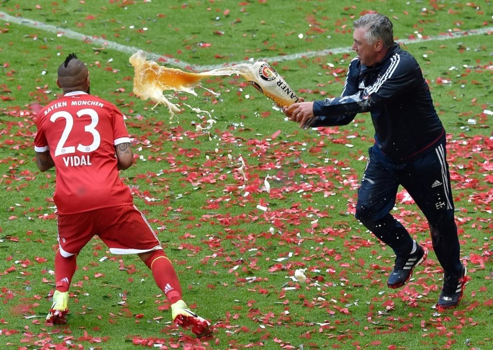 Le coach italien du Bayern, Carlo Ancelotti lance de la bière à Arturo Vidal. AFP
