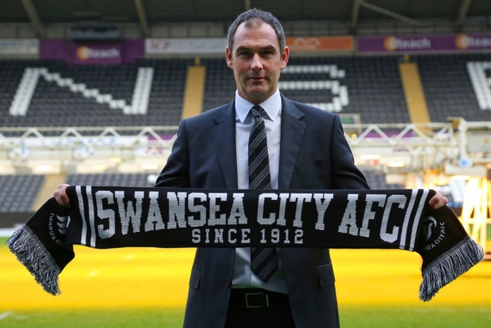 Paul Clement poses for a photograph with a Swansea scarf. AFP