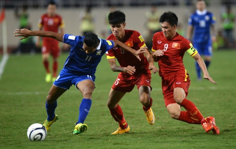 Thailands Mongkol (left) holds off two Vietnamese players during a World Cup 2018 qualifier at My Dinh stadium in Hanoi, on October 13, 2015. Thailand defeated Vietnam 3-0