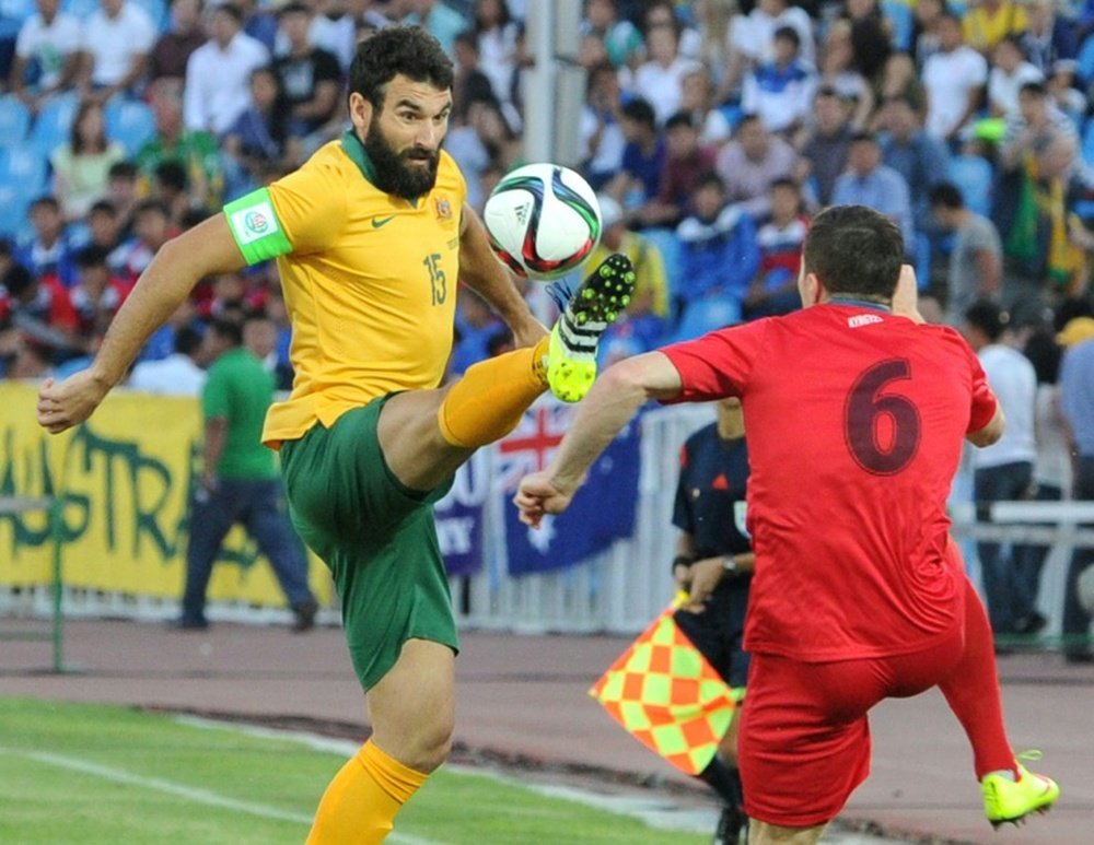 Australias Mile Jedinak (L) and Kyrgyzstans Viktor Maier during the FIFA World Cup 2018 Group B qualifying match in Bishkek on June 16, 2015