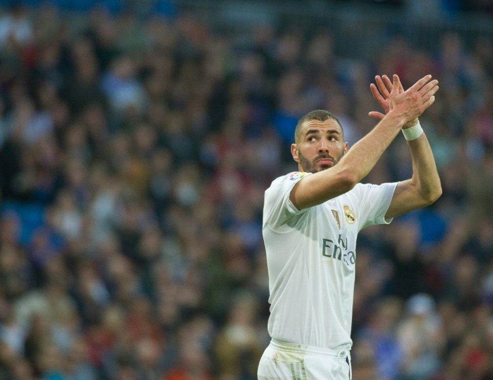 Real Madrids French forward Karim Benzema greets supporters as he leaves the pitch in Madrid on December 5, 2015