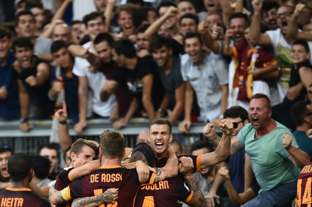 Romas forward Edin Dzeko (C) celebrates with teammates after scoring during their Italian Serie A football match against Juventus on August 30, 2015 in Rome
